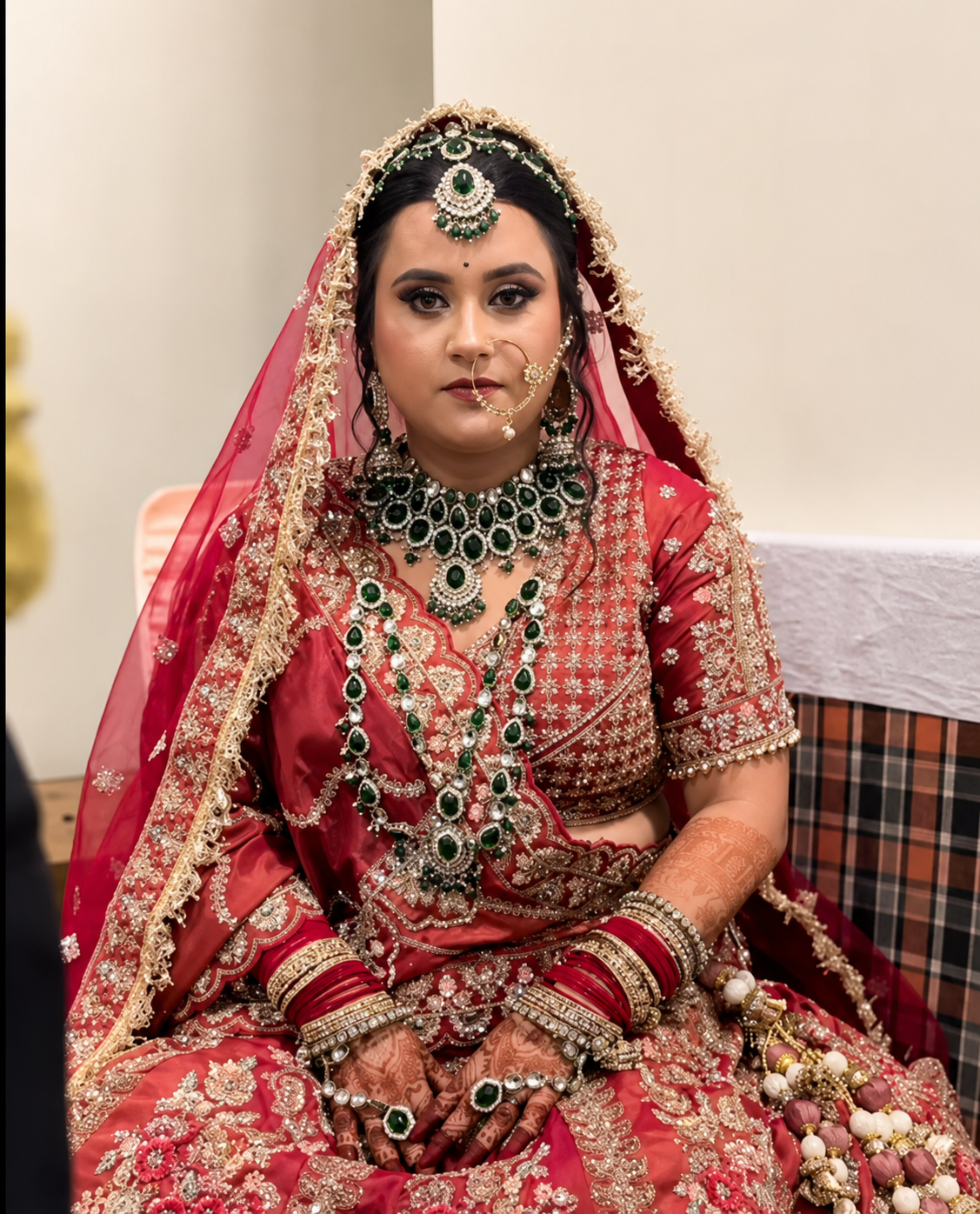 Bride in traditional red wedding lehenga with heavy jewelry